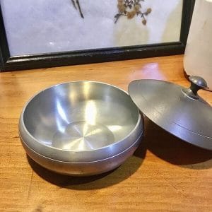 Vintage pewter trinket bowl with the lid resting beside it, showing the smooth spun interior